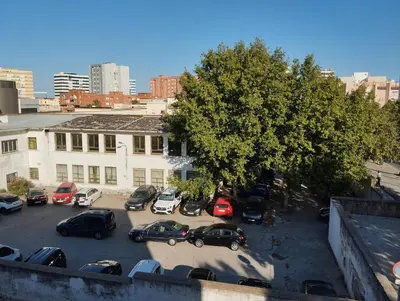 a parking lot with cars parked in front of a building at Cadiz Rented in Cádiz