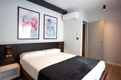 a bedroom with a bed and two pictures on the wall at Apartamentos La Espadaña in Rota