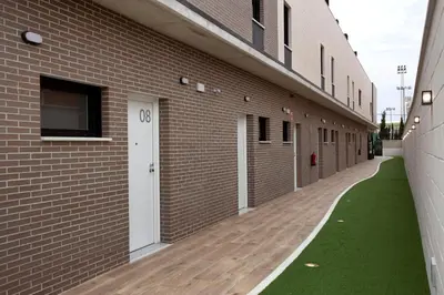 a hallway of a brick building with a white door at Apartamentos La Espadaña in Rota
