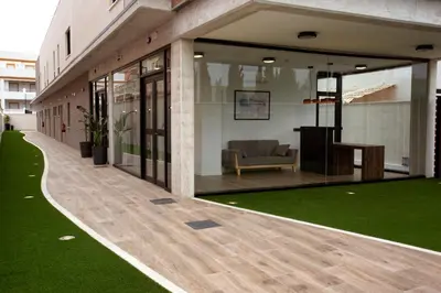 a building with a green lawn in front of it at Apartamentos La Espadaña in Rota