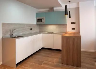 a kitchen with white cabinets and a sink at Apartamentos La Espadaña in Rota