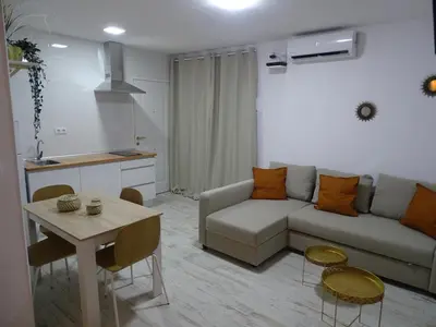a living room with a couch and a table at Casasjerezanas Loft Aitana in Jerez de la Frontera