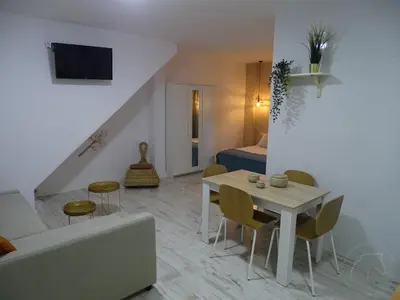 a living room with a couch and a table and a bed at Casasjerezanas Loft Aitana in Jerez de la Frontera