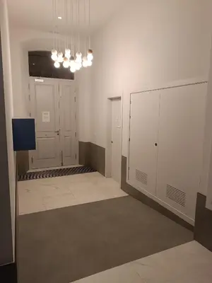 an empty room with white cabinets and a room with a television at APARTAMENTO LUPA in Cádiz