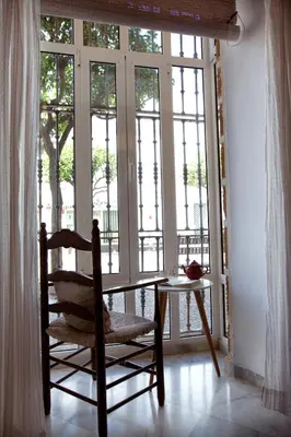 a chair and a table in a room with a window at Barroso 4 by 7Escalones in Rota