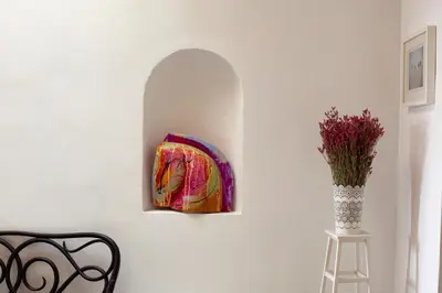 a painting hanging on a wall next to a vase of flowers at Barroso 4 by 7Escalones in Rota