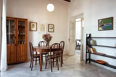 a dining room with a wooden table and chairs at Barroso 4 by 7Escalones in Rota
