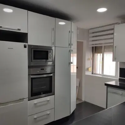 a kitchen with white cabinets and stainless steel appliances at Ohana in San Fernando