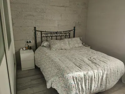 a bedroom with a bed and a brick wall at Ohana in San Fernando