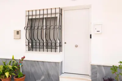 a white door with a window and plants at Apartamento AGUADULCE in Sanlúcar de Barrameda