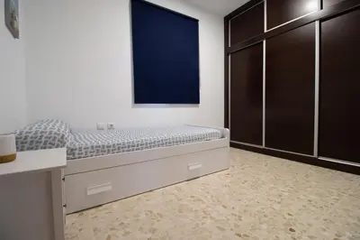 a bedroom with a bed with a large window at Casa Sumariva in Sanlúcar de Barrameda