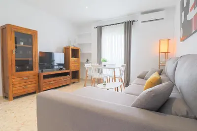 a living room with a couch and a tv at Casa Sumariva in Sanlúcar de Barrameda