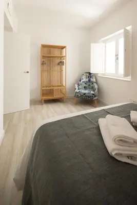 a bedroom with a bed and a chair at Suite Catedral Little Apartments in Cádiz