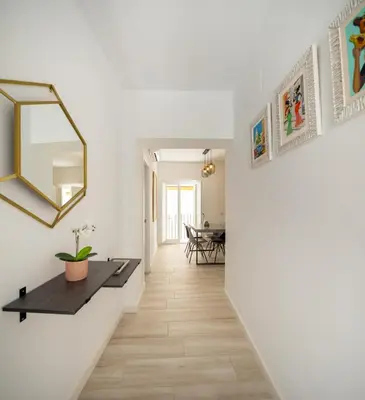 a hallway with a table and a mirror on the wall at Suite Catedral Little Apartments in Cádiz