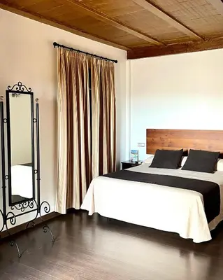 a bedroom with a large bed and a mirror at El Mirador del Valle in San Jose del Valle