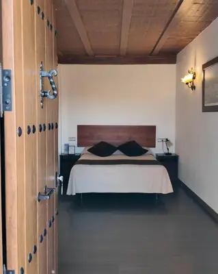 a bedroom with a bed with a wooden head board at El Mirador del Valle in San Jose del Valle