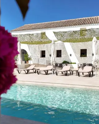 a patio with tables and chairs next to a pool at El Mirador del Valle in San Jose del Valle