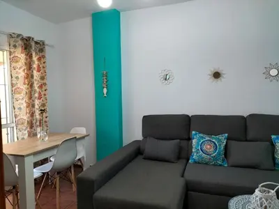 a living room with a couch and a table at APARTAMENTO EN URBANIZACIÓN AL-ÁNDALUs CERCA DE LA PLAYA DE LA BARROSA in Chiclana de la Frontera