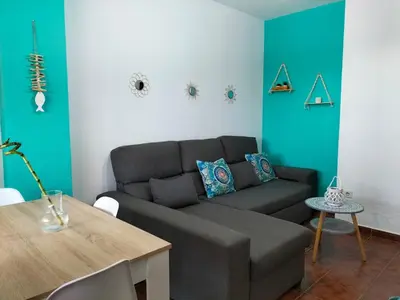 a living room with a couch and a table at APARTAMENTO EN URBANIZACIÓN AL-ÁNDALUs CERCA DE LA PLAYA DE LA BARROSA in Chiclana de la Frontera