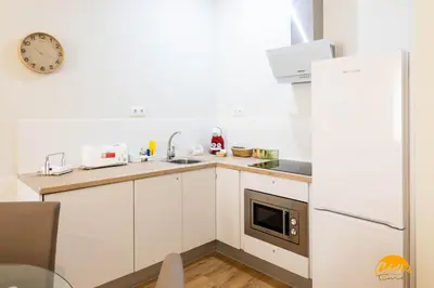 a kitchen with white cabinets and a white refrigerator at Tailor's Home by Cadiz Time in Cádiz