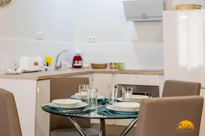 a table with plates and glasses on it in a kitchen at Tailor's Home by Cadiz Time in Cádiz