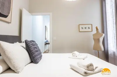 a bedroom with a white bed with towels on it at Tailor's Home by Cadiz Time in Cádiz