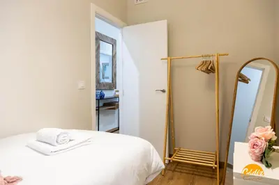 a bedroom with a white bed and a mirror at Tailor's Home by Cadiz Time in Cádiz