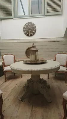 a table in a room with two chairs and a clock at Oasis de Bornos Chambres in Bornos