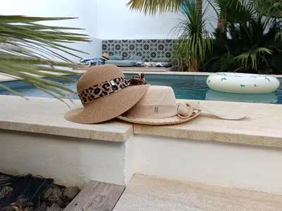 a hat sitting on a ledge next to a swimming pool at Oasis de Bornos Chambres in Bornos
