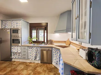 a kitchen with blue cabinets and a counter top at Villa Zahara in Chiclana de la Frontera