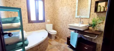 a bathroom with a tub and a sink and a toilet at Villa Zahara in Chiclana de la Frontera