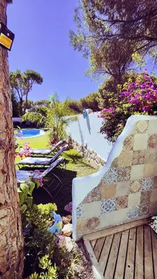 a bench sitting on a wooden deck next to a pool at Villa Zahara in Chiclana de la Frontera