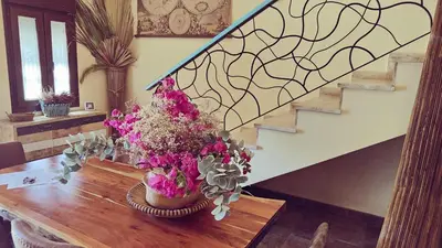 a table with flowers on it next to a staircase at Villa Zahara in Chiclana de la Frontera