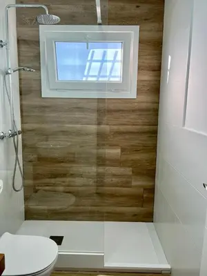 a bathroom with a shower and a toilet and a window at Villa Olivia con Piscina, Jardin y Parking in Chiclana de la Frontera