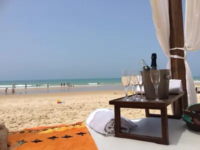 a table with glasses and wine bottles on the beach at Villa Olivia con Piscina, Jardin y Parking in Chiclana de la Frontera