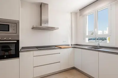 a white kitchen with a sink and a window at Casa Playa Andres in Conil de la Frontera