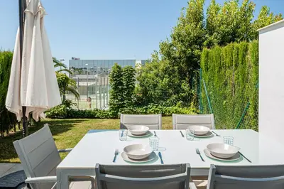 a white table with chairs and an umbrella at Casa Playa Andres in Conil de la Frontera