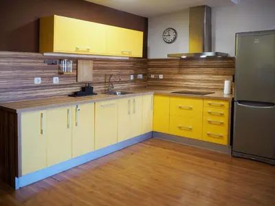 a kitchen with yellow cabinets and a refrigerator at Loft con encanto cerca del centro + Parking in Jerez de la Frontera