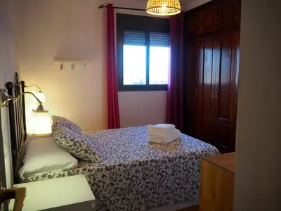 a bedroom with a bed with a lamp and a window at Loft con encanto cerca del centro + Parking in Jerez de la Frontera
