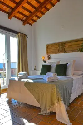 a bedroom with a large bed with a large window at La Esperanza in Medina Sidonia