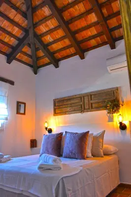 a bedroom with a large bed with a wooden ceiling at La Esperanza in Medina Sidonia