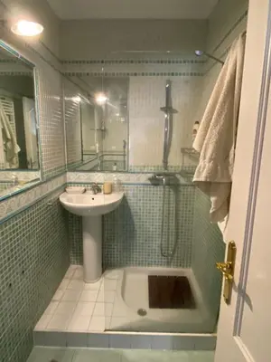 a bathroom with a sink and a shower with a tub at Ático Cádiz Playa in Cádiz