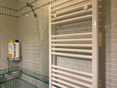 a shower with green tiled walls and a window with shutter at Ático Cádiz Playa in Cádiz
