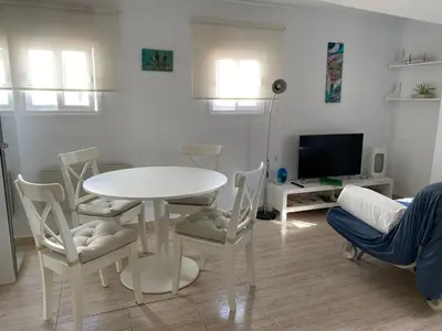 a living room with a white table and chairs at Ático Cádiz Playa in Cádiz