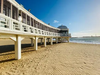 a pier on the beach next to the water at Ático Cádiz Playa in Cádiz