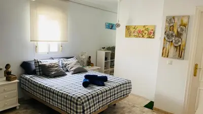 a bedroom with a bed with a blue teddy bear on it at Ático Cádiz Playa in Cádiz