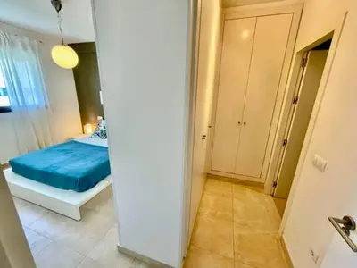 a bedroom with a bed with a blue blanket at GATU PREMIUM Racimo, terraza, aire ac, piscina comun, wifi y parking 