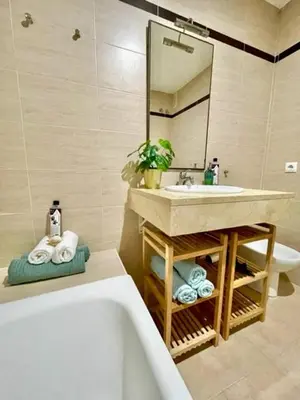 a bathroom with a tub and a sink and a mirror at GATU PREMIUM Racimo, terraza, aire ac, piscina comun, wifi y parking 