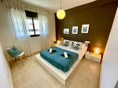 a bedroom with a large bed with a blue blanket at GATU PREMIUM Racimo, terraza, aire ac, piscina comun, wifi y parking 