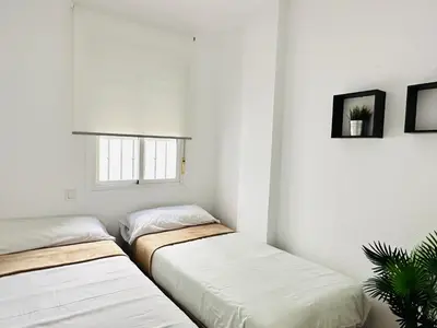 a small room with a bed and a window at Al Andalus in Chiclana de la Frontera